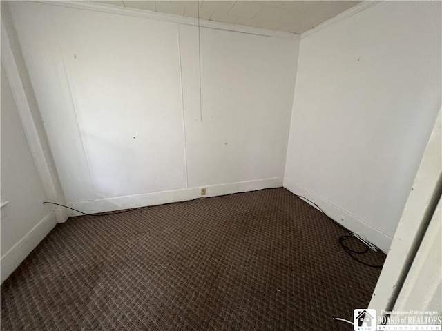 empty room with dark carpet and ornamental molding