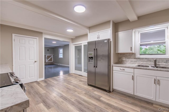 kitchen featuring beam ceiling, white cabinetry, sink, and stainless steel refrigerator with ice dispenser