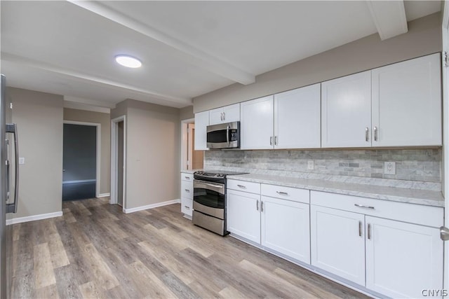 kitchen featuring light hardwood / wood-style flooring, decorative backsplash, appliances with stainless steel finishes, beam ceiling, and white cabinetry