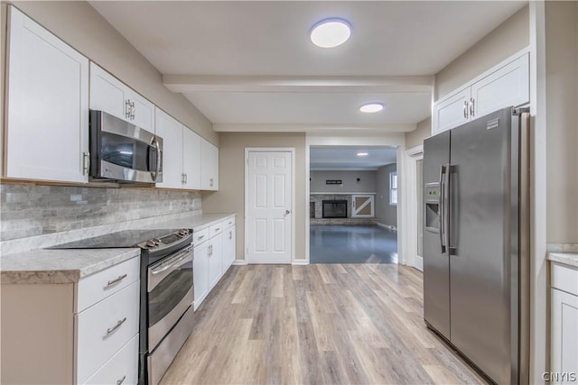 kitchen featuring white cabinets, light hardwood / wood-style flooring, decorative backsplash, appliances with stainless steel finishes, and beamed ceiling