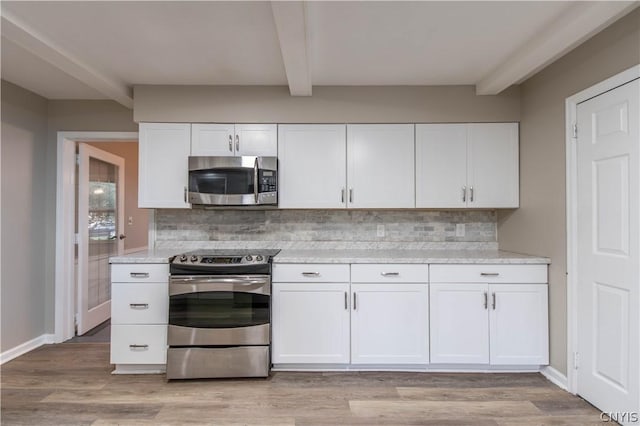 kitchen featuring white cabinets, appliances with stainless steel finishes, and tasteful backsplash