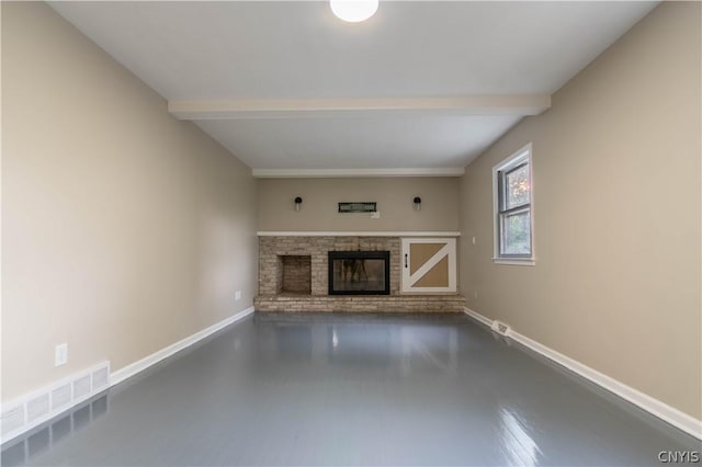 unfurnished living room featuring beamed ceiling and a brick fireplace