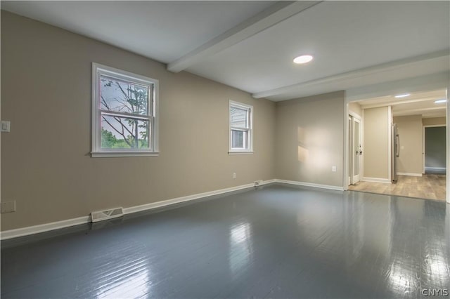 unfurnished room featuring beamed ceiling and wood-type flooring