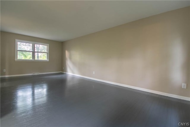 unfurnished room with dark hardwood / wood-style flooring