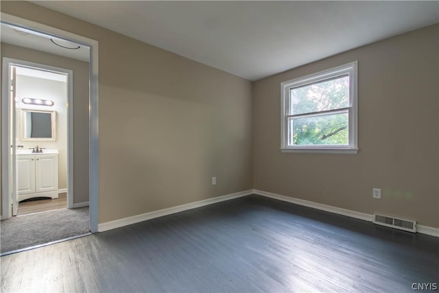 unfurnished room with dark wood-type flooring and sink