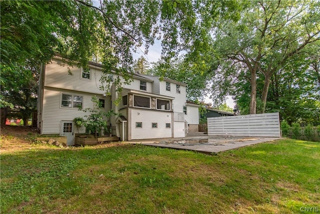 rear view of property featuring a patio area, a sunroom, and a yard