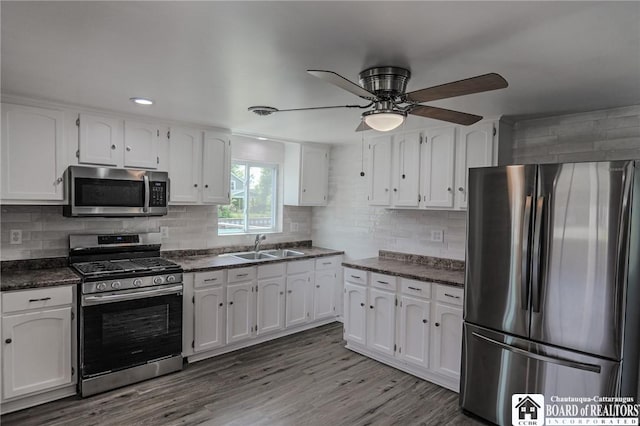 kitchen featuring hardwood / wood-style floors, stainless steel appliances, white cabinetry, and ceiling fan