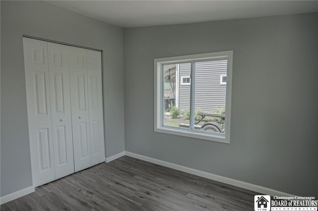 unfurnished bedroom with a closet and hardwood / wood-style flooring