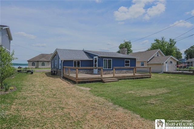 back of property featuring a lawn and a deck