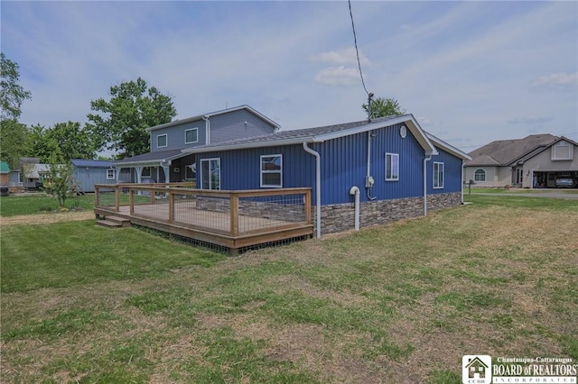 rear view of property with a yard and a wooden deck