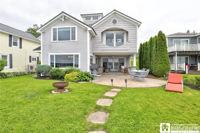 rear view of house featuring a lawn and a patio area