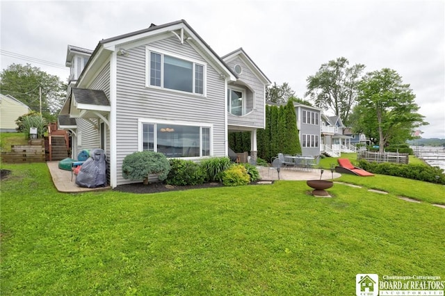 rear view of property featuring a yard and a patio