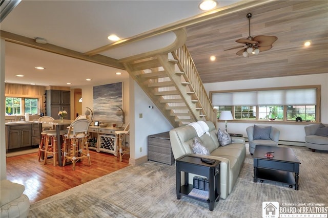 living room with wood-type flooring, ceiling fan, and a baseboard heating unit