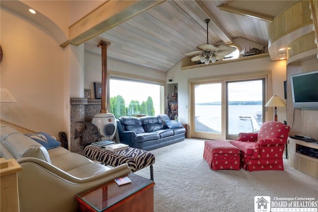 carpeted living room featuring a healthy amount of sunlight, beamed ceiling, wooden ceiling, and ceiling fan