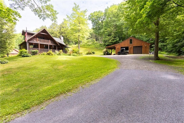 exterior space featuring an outbuilding, a front yard, and a garage