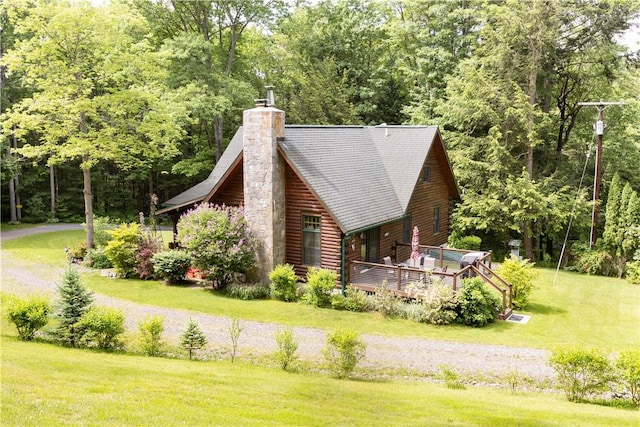 view of side of property with a chimney, a deck, and a yard