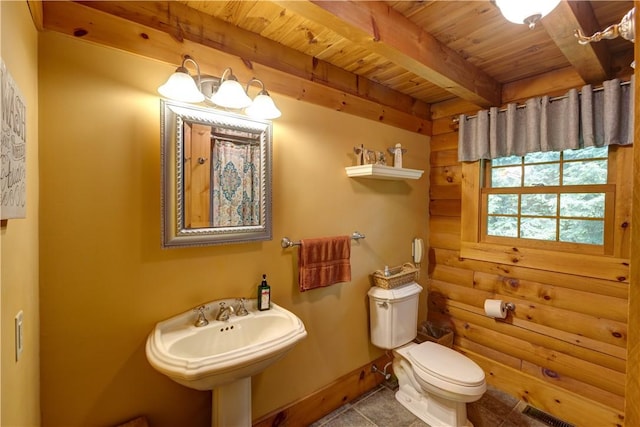 half bath with log walls, toilet, wood ceiling, a sink, and beamed ceiling