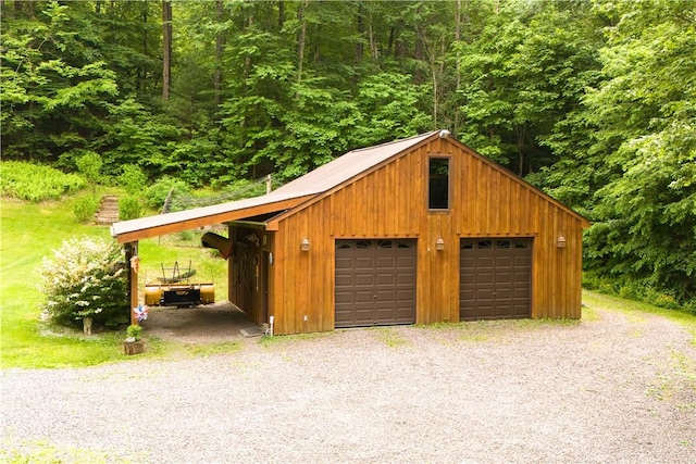 garage with a detached garage and a wooded view