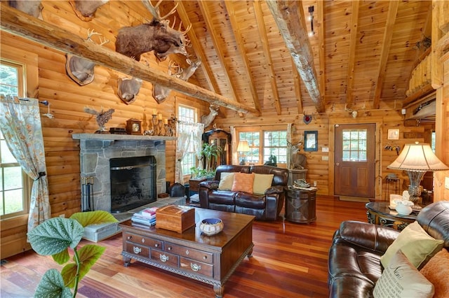 living room featuring wood ceiling, a stone fireplace, wood finished floors, and beam ceiling