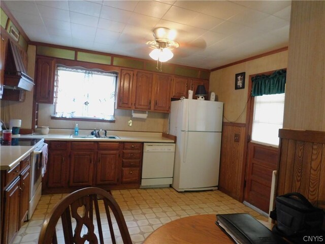 kitchen featuring white appliances, plenty of natural light, ceiling fan, and custom range hood