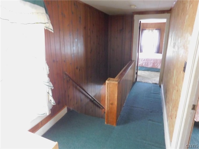 staircase with carpet floors and wood walls