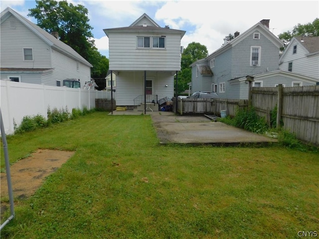 back of property featuring a patio area, a lawn, and a fenced backyard