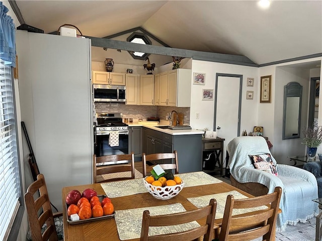 kitchen with gray cabinets, decorative backsplash, lofted ceiling, and appliances with stainless steel finishes