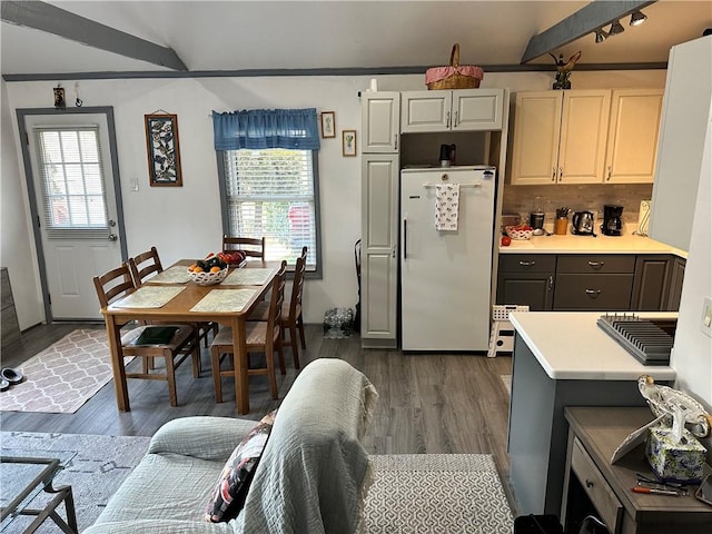 kitchen with decorative backsplash, white refrigerator, and dark hardwood / wood-style floors