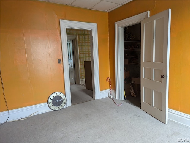 carpeted empty room featuring a paneled ceiling