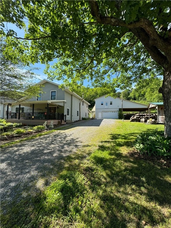 view of side of property with a porch, a garage, and a lawn