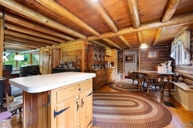 kitchen with wood ceiling, beam ceiling, light hardwood / wood-style floors, a kitchen island, and wood walls