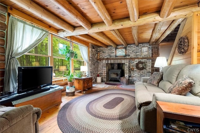 living room with hardwood / wood-style flooring, a wood stove, wood ceiling, and beamed ceiling