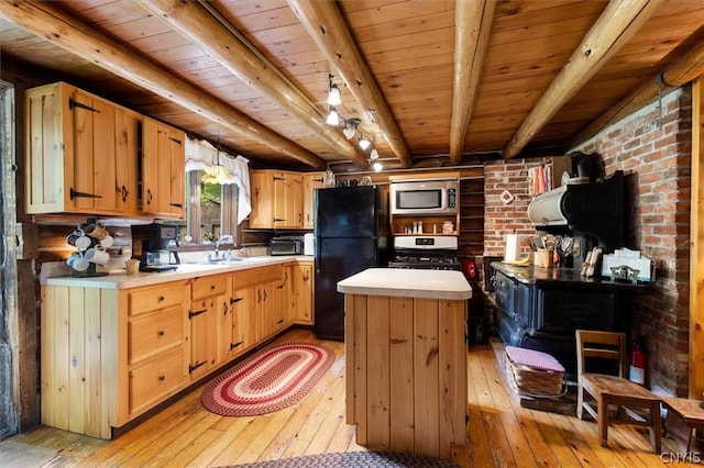 kitchen featuring sink, light hardwood / wood-style flooring, a kitchen island, beamed ceiling, and stainless steel appliances