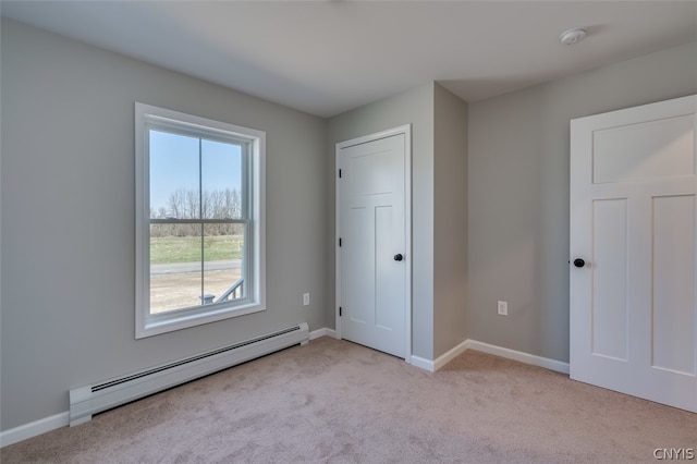 unfurnished room featuring light colored carpet and a baseboard radiator