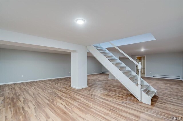 22218 Freedom Dr, Champion, NY 13619 - finished basement with a baseboard heating unit, baseboards, wood finished floors, and stairs