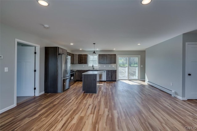 22218 Freedom Dr, Champion, NY 13619 - kitchen with stainless steel appliances, wood finished floors, a baseboard heating unit, baseboards, and open floor plan