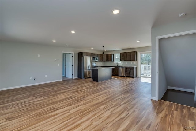 22218 Freedom Dr, Champion, NY 13619 - kitchen featuring a center island, dark brown cabinets, a sink, open floor plan, and stainless steel appliances