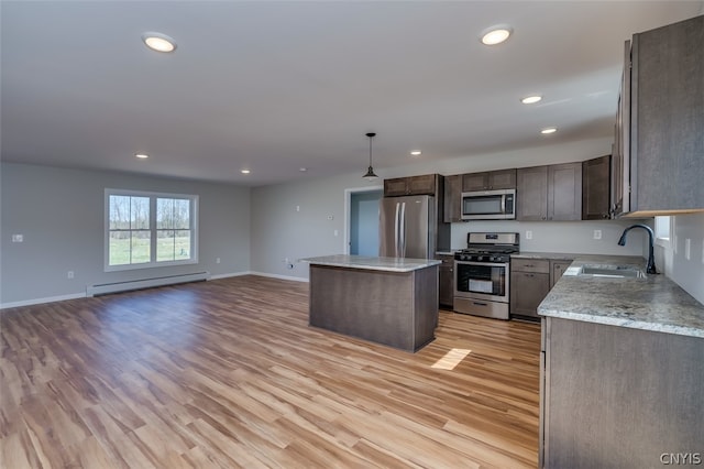 kitchen with stainless steel appliances, light wood-type flooring, a kitchen island, sink, and a baseboard radiator