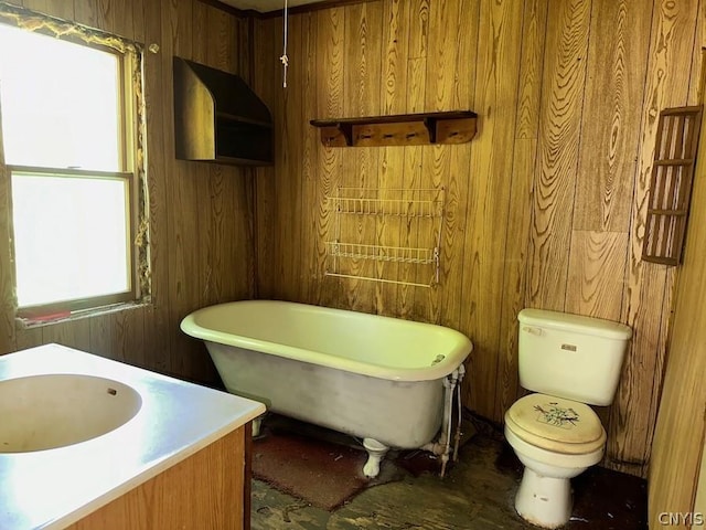 bathroom featuring vanity, toilet, a tub, and wood walls