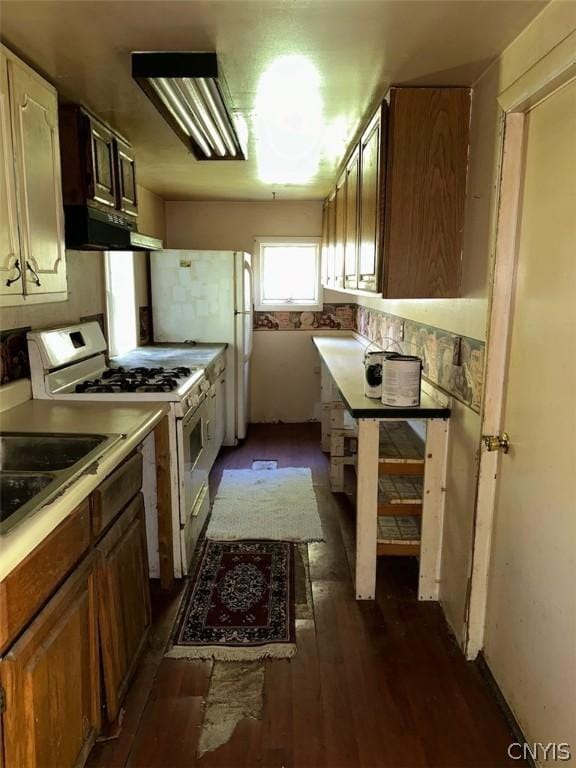 kitchen featuring ventilation hood, white appliances, and dark wood-type flooring