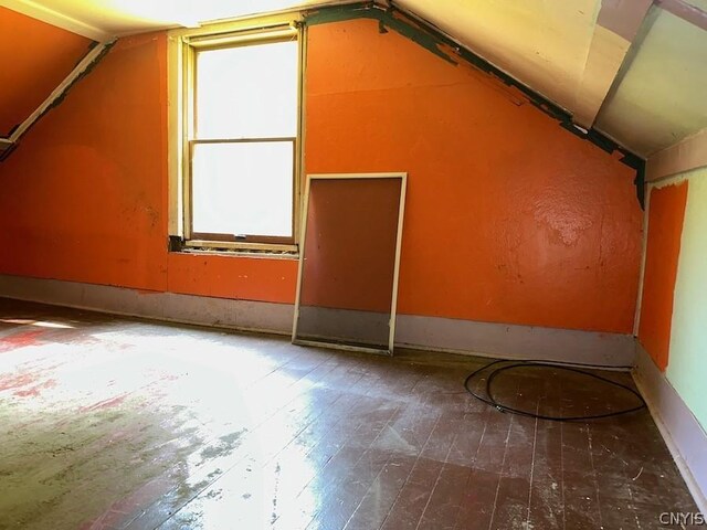 bonus room with dark hardwood / wood-style flooring and vaulted ceiling