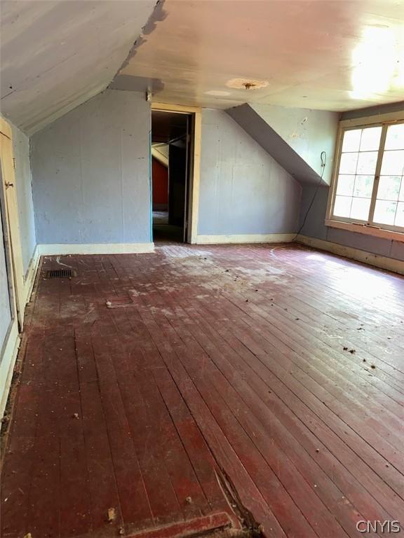 additional living space featuring dark hardwood / wood-style floors and lofted ceiling