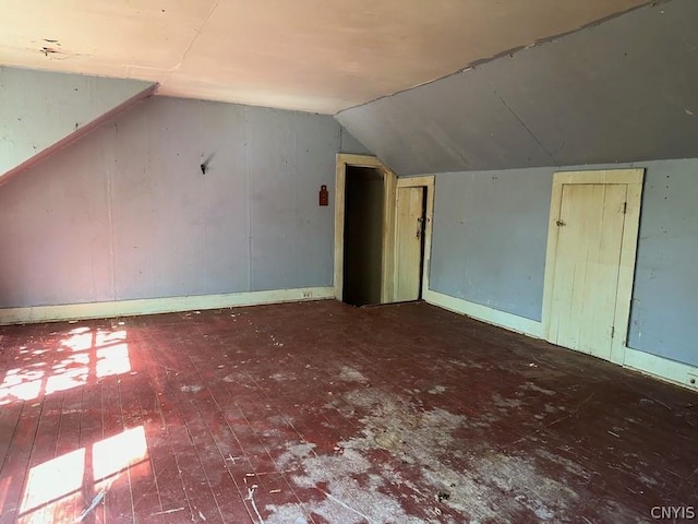 additional living space with hardwood / wood-style flooring and lofted ceiling