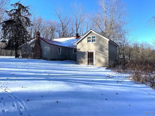 view of snow covered rear of property