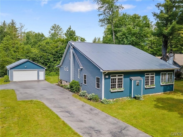 view of front of house with a garage, metal roof, an outdoor structure, and a front yard