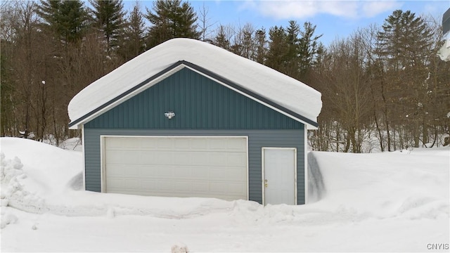 snow covered garage with a garage