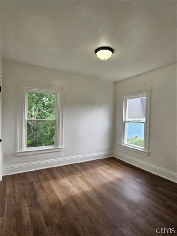 unfurnished room featuring dark wood-type flooring