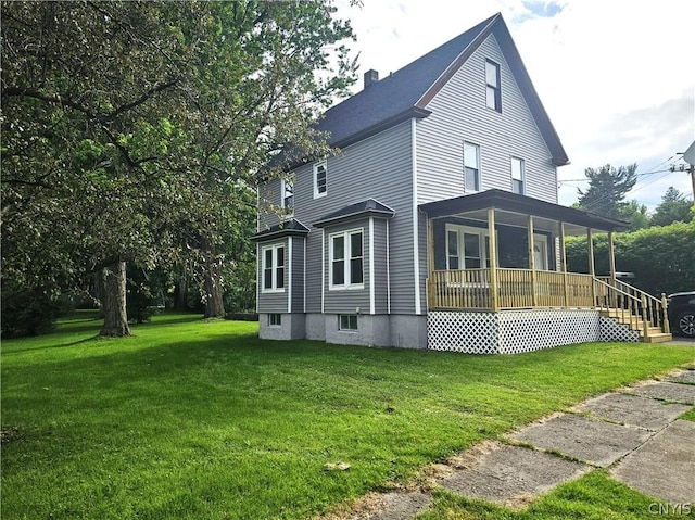 view of side of property with a yard and covered porch