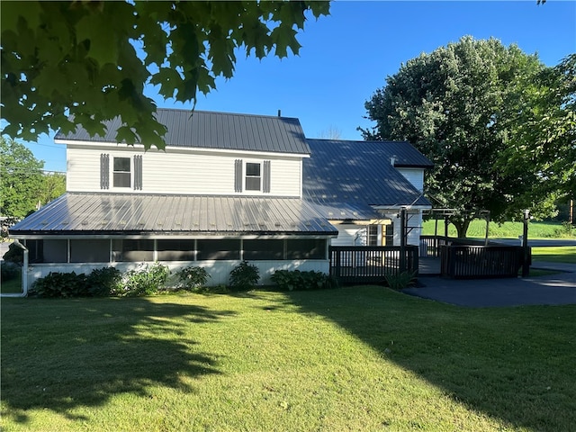 rear view of property featuring a yard and a deck