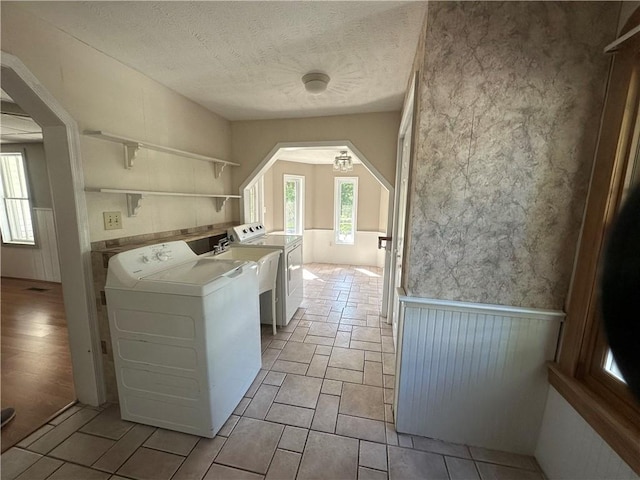 clothes washing area featuring washer and clothes dryer and a textured ceiling